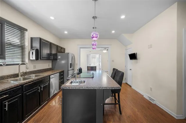 a kitchen with stainless steel appliances granite countertop a sink a stove top oven a counter space and cabinets