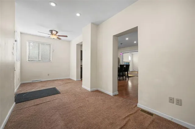 an empty room and chandelier fan