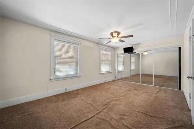 an empty room with a window and a fan