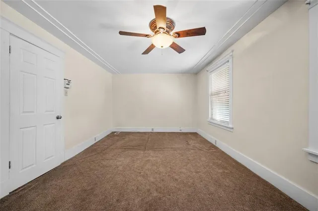 a view of a room with a ceiling fan and a window