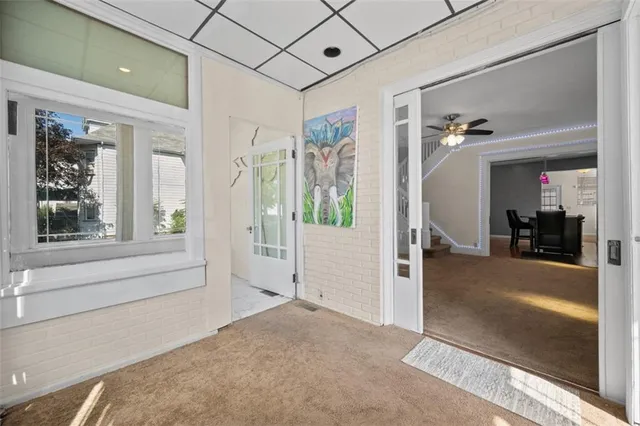 a view of a hallway with a livingroom and furniture