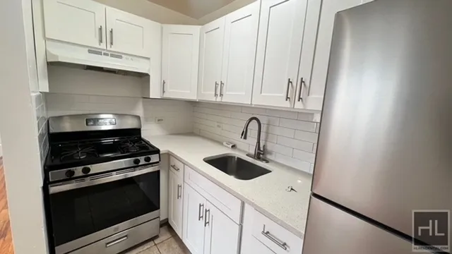 a kitchen with white cabinets and appliances
