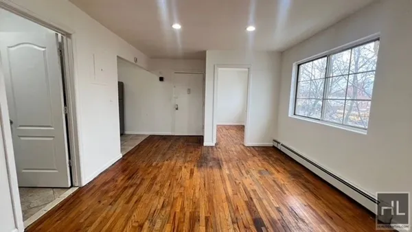 a view of a room with wooden floor and window