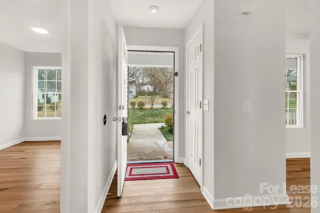 a room with stainless steel appliances kitchen island granite countertop a table chairs and a refrigerator