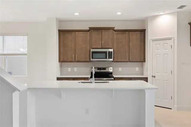 a kitchen with appliances a sink and cabinets