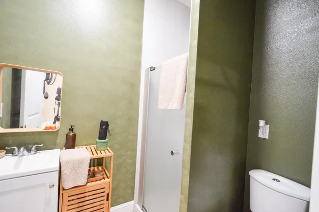 a bathroom with a sink toilet and mirror