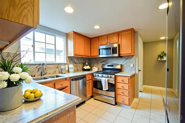 a kitchen with stainless steel appliances a sink a counter top space cabinets and a window