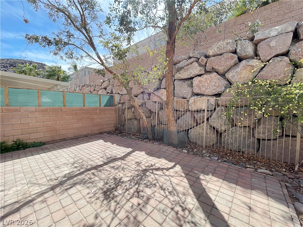 691 Principle Point Avenue Henderson, NV 89012 - Photo 29 of 30 A spacious brick paver patio, ideal for outdoor gatherings, abuts a natural rock wall.