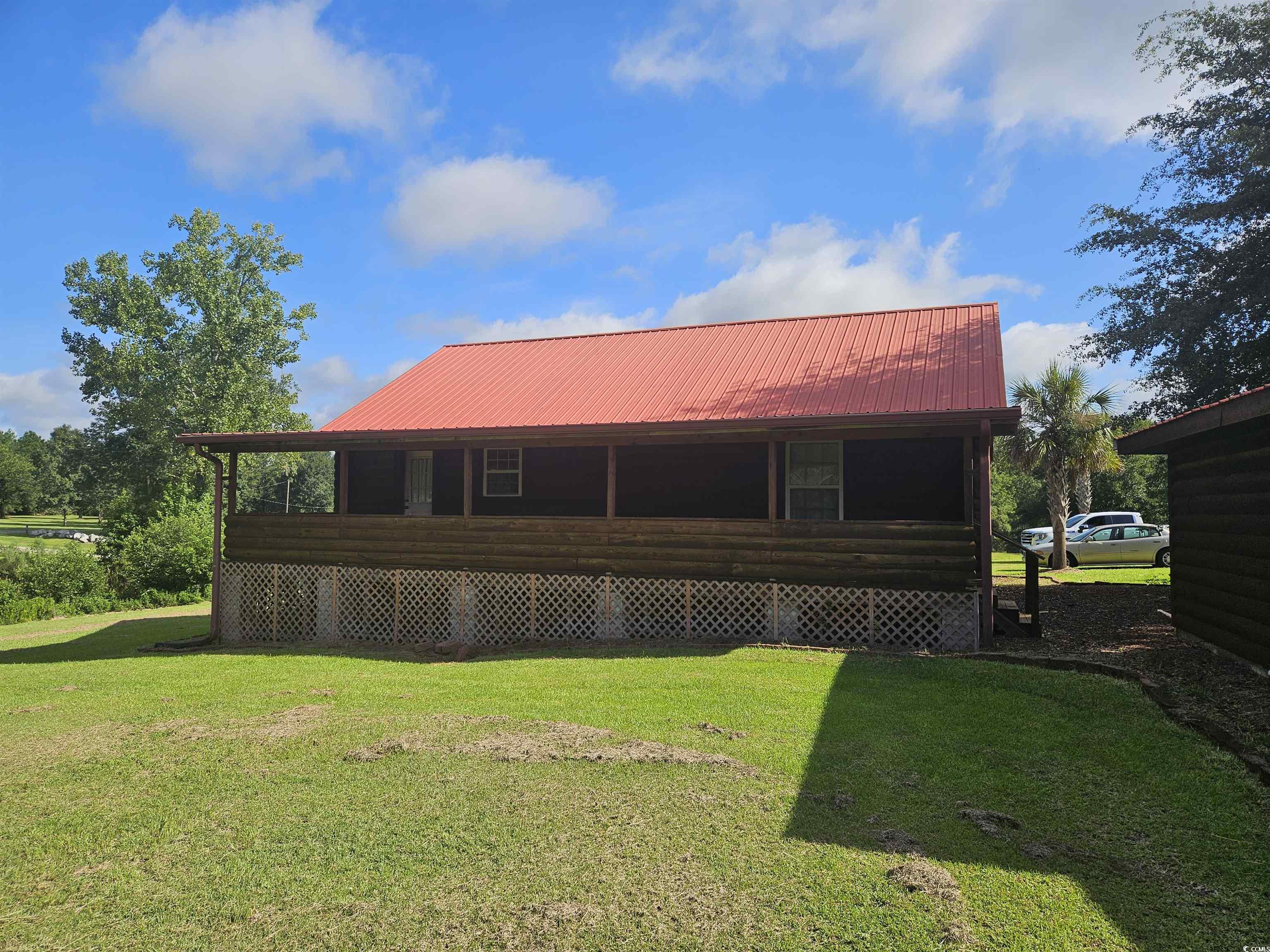 115 Roberts Lane Salters, SC 29590 - Photo 2 of 14 Rear view of house featuring a yard, a metal roof, and a porch