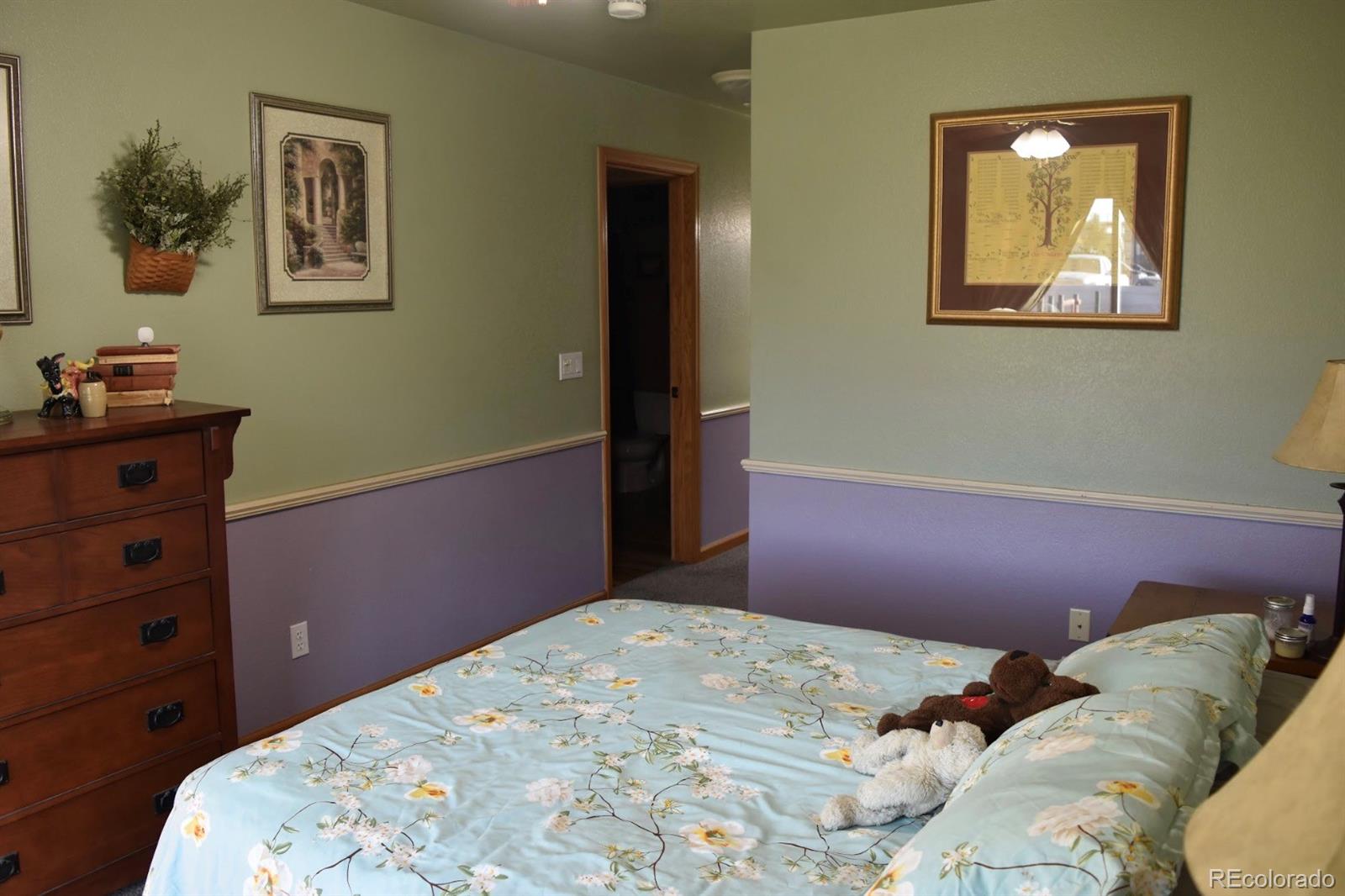 1426 3rd Street Fort Lupton, CO 80621 - Photo 11 of 50 a bedroom with a bed and wooden floor