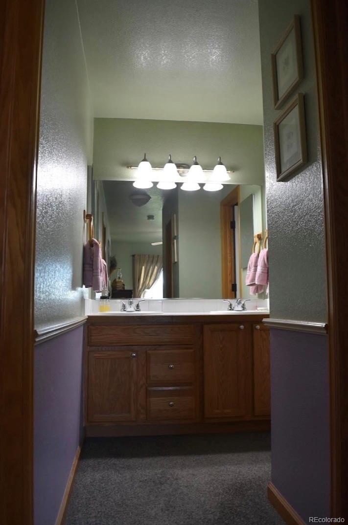1426 3rd Street Fort Lupton, CO 80621 - Photo 13 of 50 a bathroom with a sink and mirror