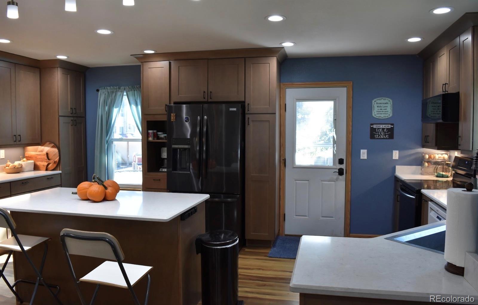 1426 3rd Street Fort Lupton, CO 80621 - Photo 5 of 50 a kitchen with a sink a refrigerator and wooden cabinets