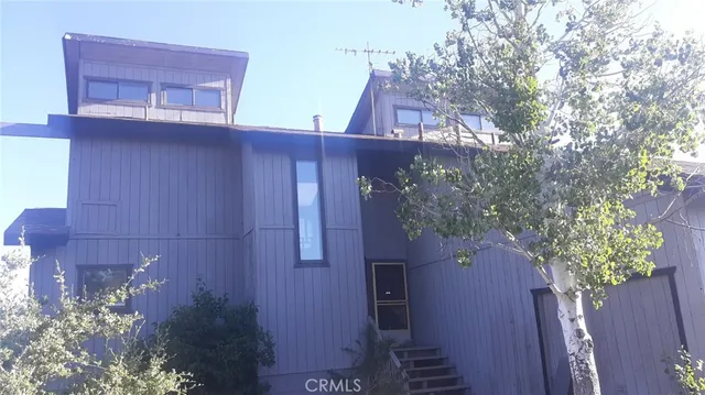 a view of a wooden door and a tree