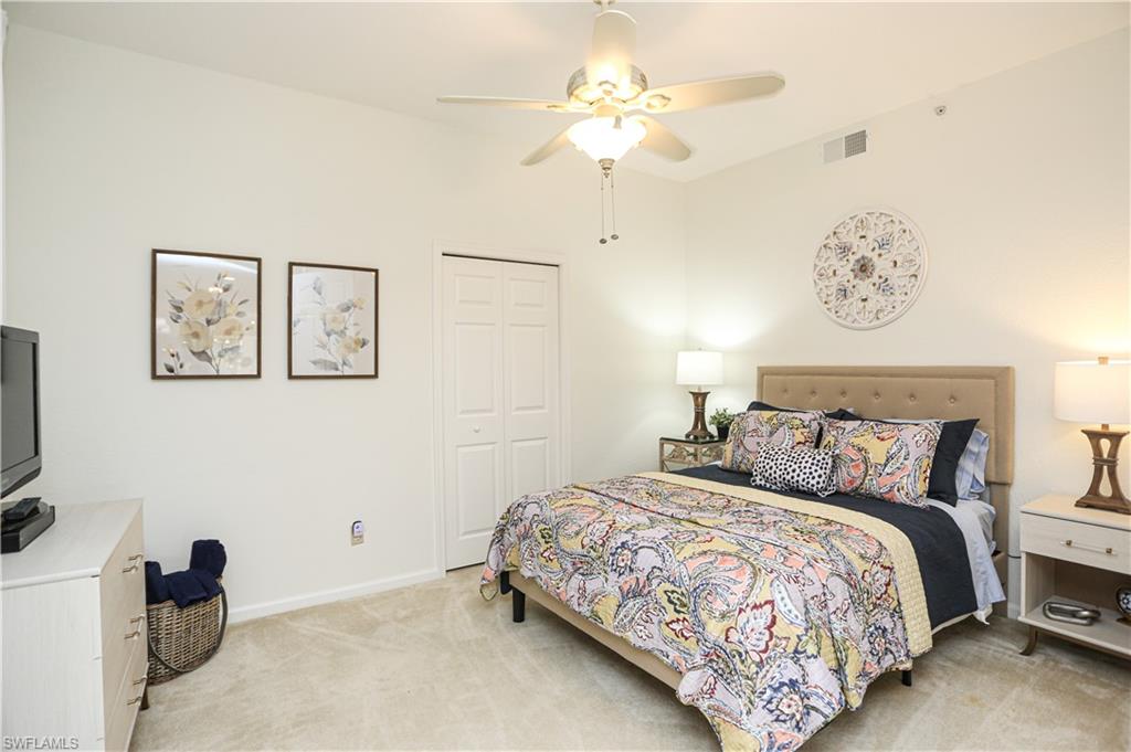 3930 Deer Crossing Court, Unit 3103 Naples, FL 34114 - Photo 22 of 50 a bedroom with a bed and a chandelier
