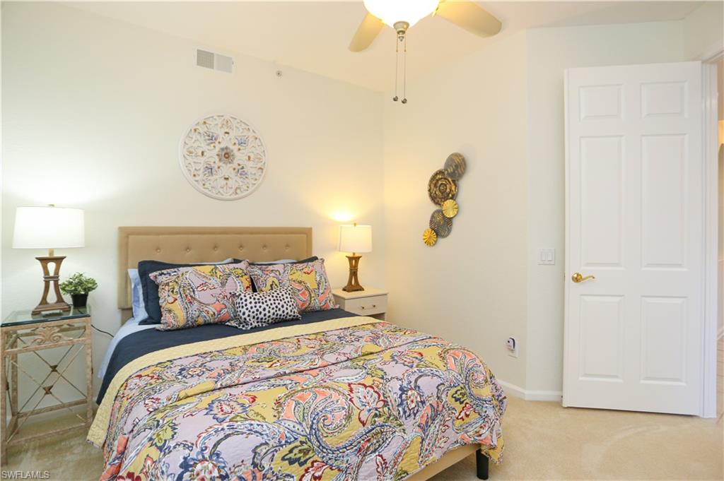 3930 Deer Crossing Court, Unit 3103 Naples, FL 34114 - Photo 23 of 50 a bedroom with a bed and lamp