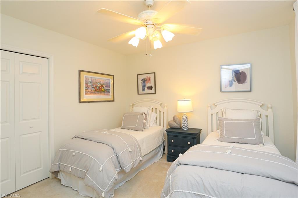 3930 Deer Crossing Court, Unit 3103 Naples, FL 34114 - Photo 25 of 50 a bedroom with a bed and a chandelier