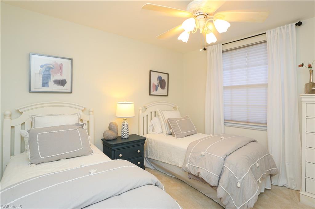 3930 Deer Crossing Court, Unit 3103 Naples, FL 34114 - Photo 26 of 50 a bedroom with a bed and a chandelier