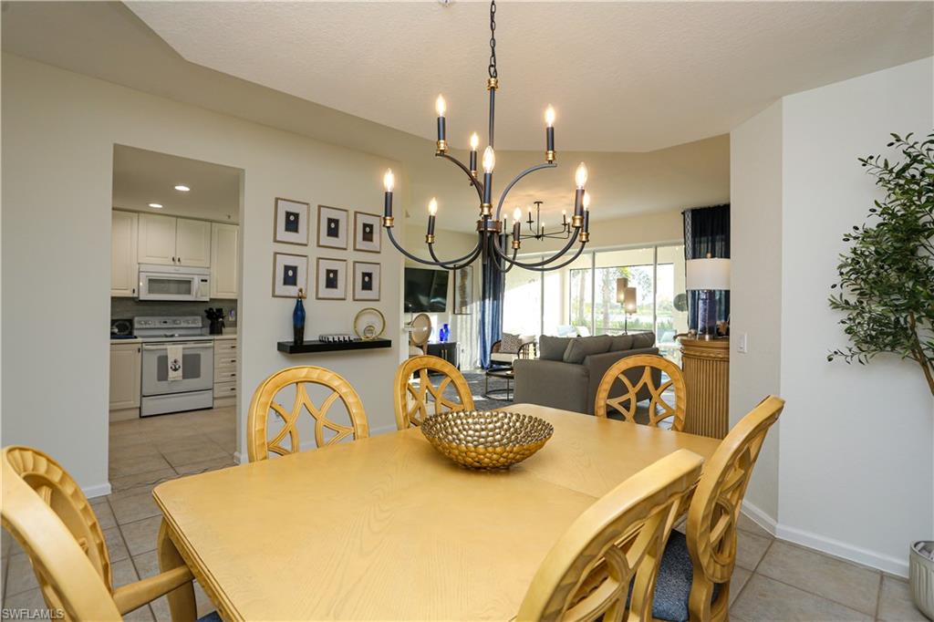 3930 Deer Crossing Court, Unit 3103 Naples, FL 34114 - Photo 33 of 50 a view of a dining room with furniture and a chandelier
