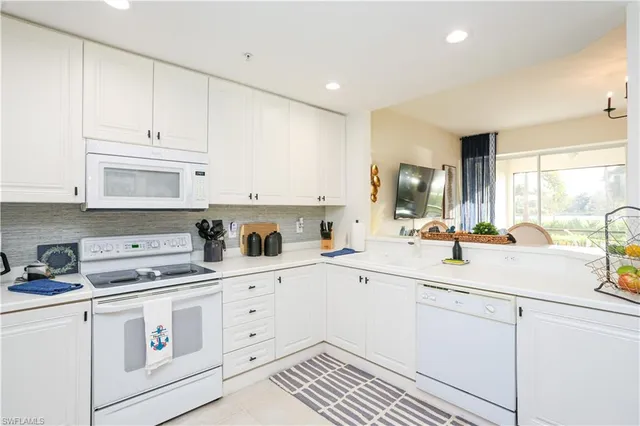 a kitchen with white cabinets and white appliances