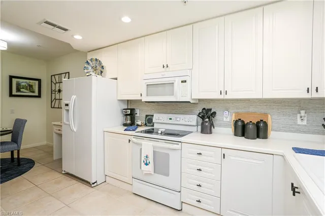 a kitchen with white cabinets and white appliances