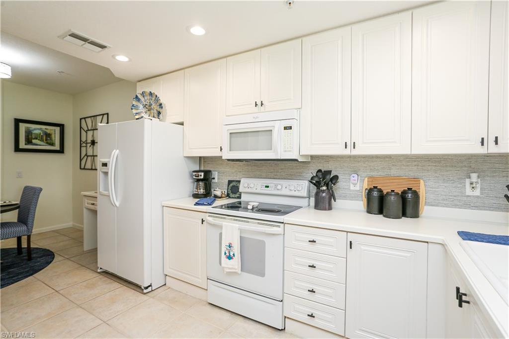 3930 Deer Crossing Court, Unit 3103 Naples, FL 34114 - Photo 39 of 50 a kitchen with white cabinets and white appliances