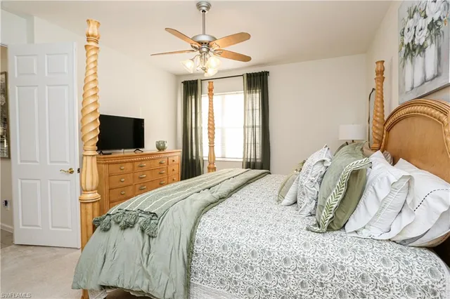a bedroom with a bed and a flat tv screen on the dresser
