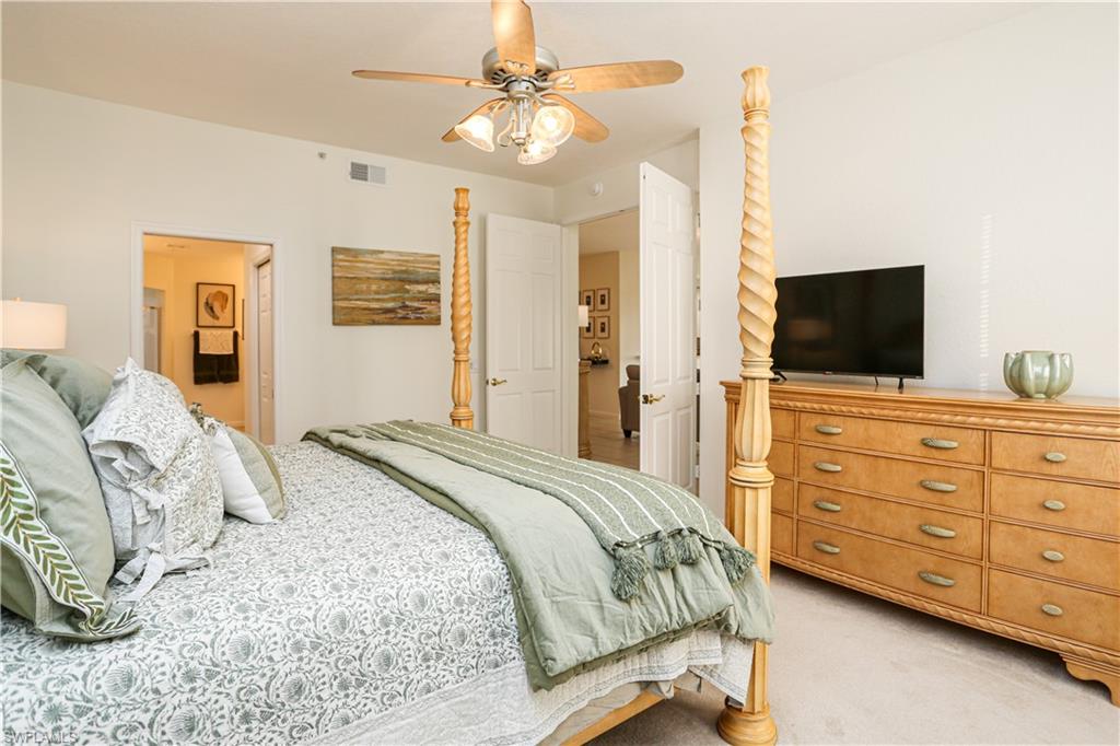 3930 Deer Crossing Court, Unit 3103 Naples, FL 34114 - Photo 47 of 50 a bedroom with a bed a dresser and flat screen tv