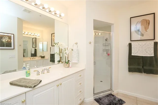 a bathroom with a granite countertop sink a mirror a vanity and shower