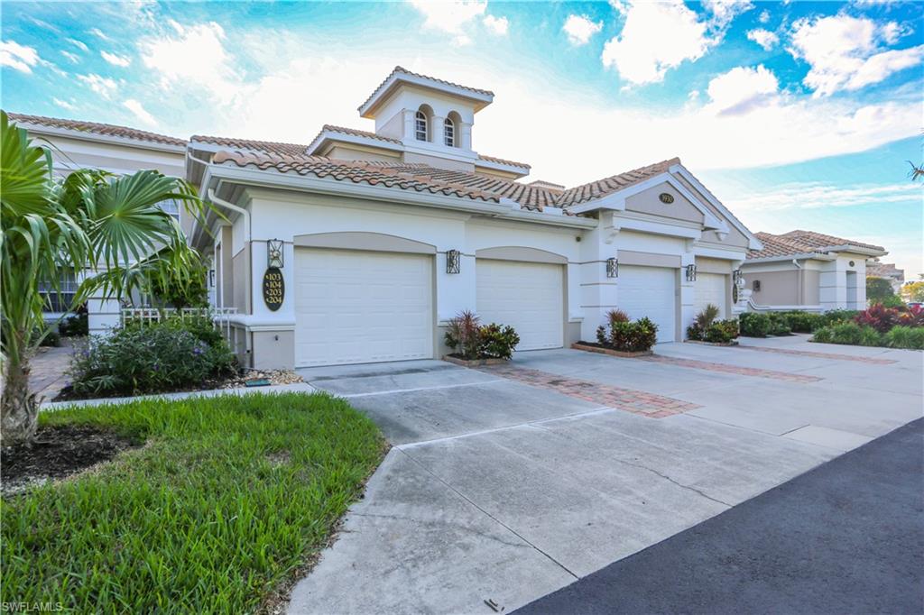 3930 Deer Crossing Court, Unit 3103 Naples, FL 34114 - Photo 8 of 50 a front view of a house with a garden and a garage