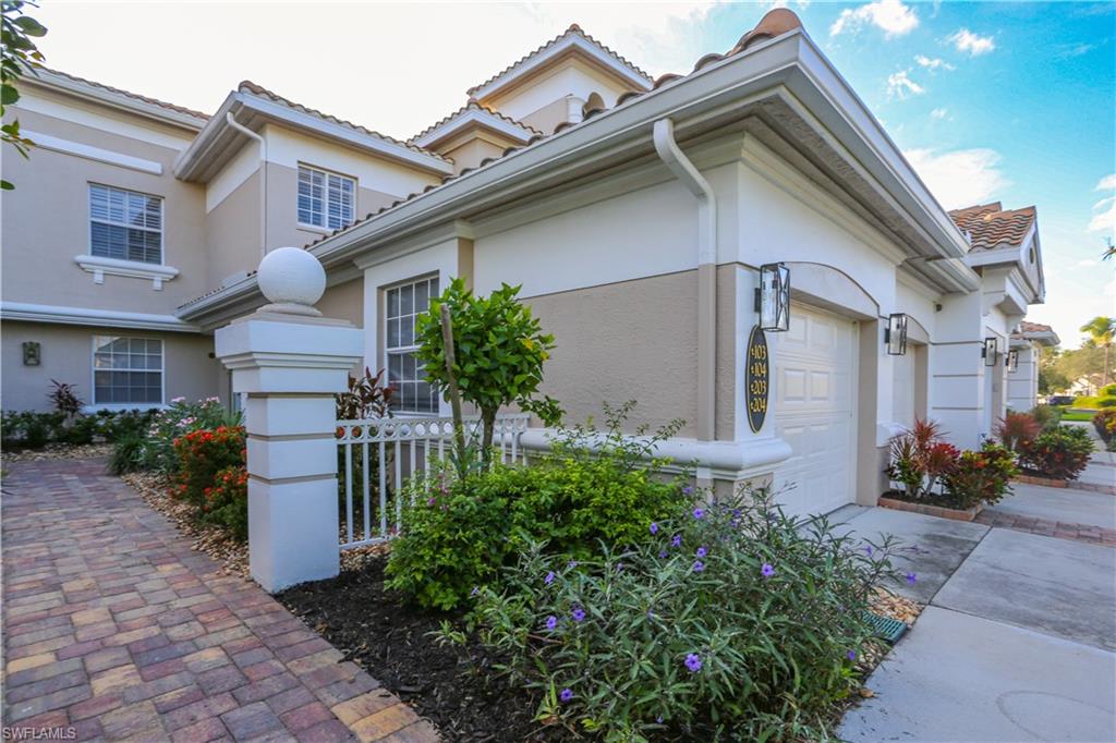 3930 Deer Crossing Court, Unit 3103 Naples, FL 34114 - Photo 10 of 50 a front view of a house with a garden