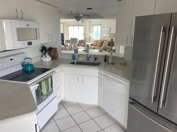 a kitchen with white cabinets and white appliances