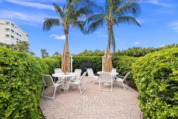 a view of a patio with a table and chairs under an umbrella
