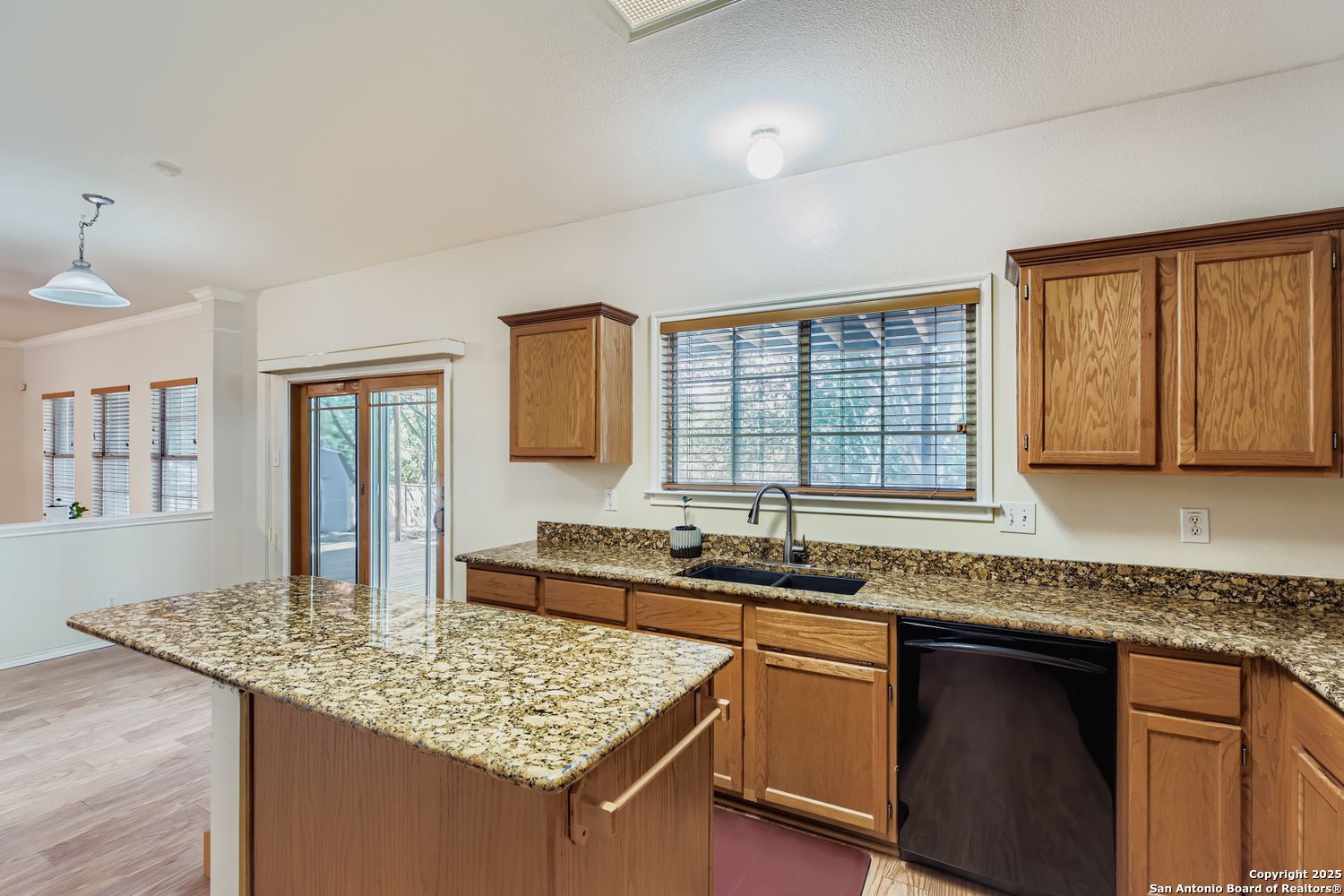 5803 Spring Pebble San Antonio, TX 78247 - Photo 11 of 27 a kitchen with granite countertop kitchen island sink and windows