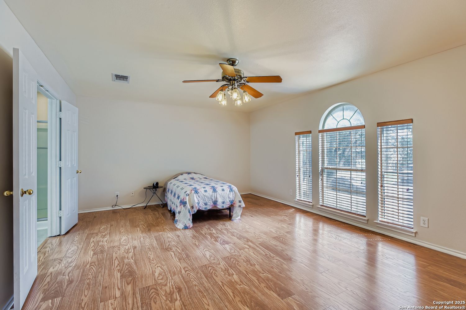 5803 Spring Pebble San Antonio, TX 78247 - Photo 15 of 27 an empty room with wooden floor chandelier fan and windows