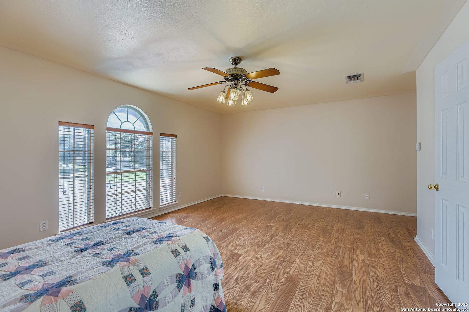 5803 Spring Pebble San Antonio, TX 78247 - Photo 17 of 27 a bedroom with a large bed and a chandelier