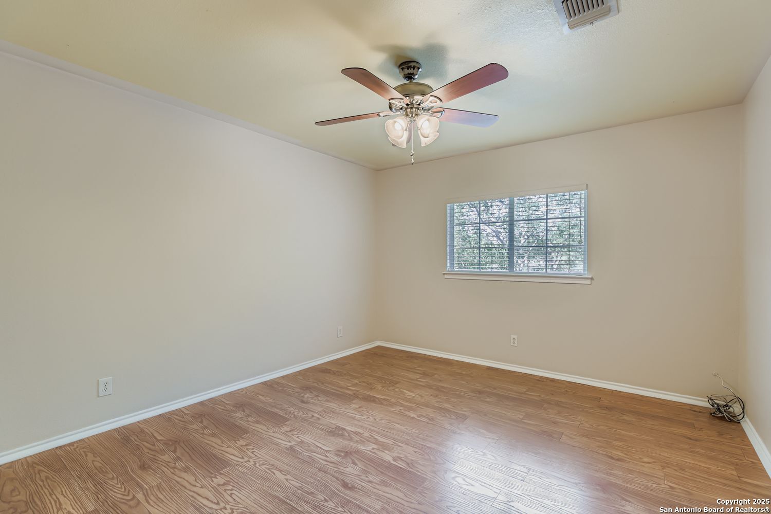 5803 Spring Pebble San Antonio, TX 78247 - Photo 19 of 27 a view of an empty room with wooden floor and a chandelier fan
