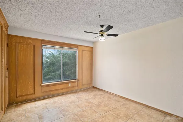 an empty room with a ceiling fan and a window