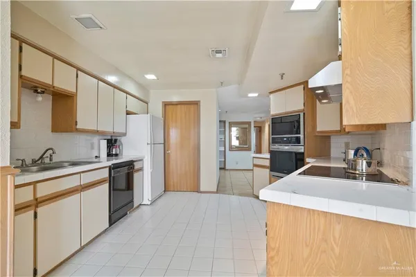 a kitchen with granite countertop a sink stove and refrigerator