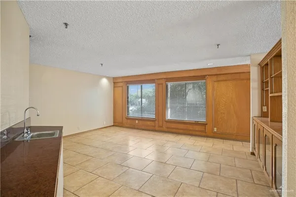 a view of an empty room with a fireplace and a window