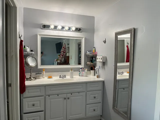 a bathroom with a sink vanity and mirror