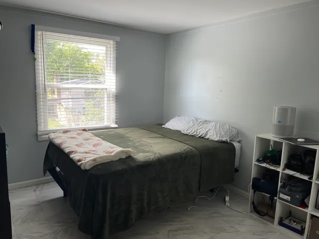 a bedroom with a bed and a window