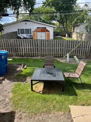 a view of a chairs and table in backyard