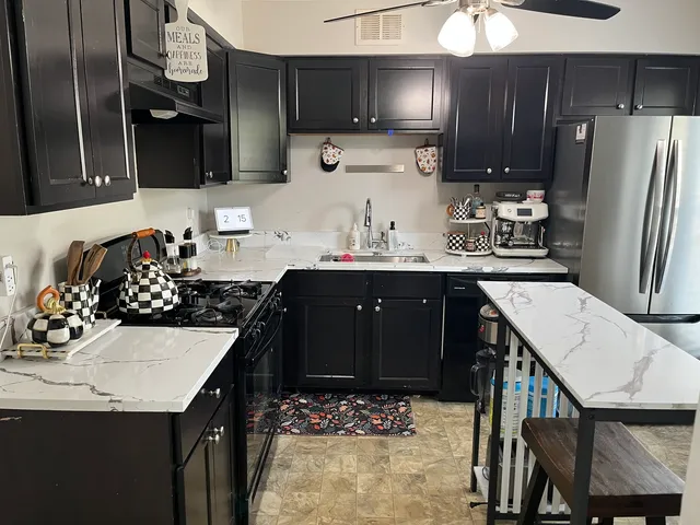 a kitchen with a sink refrigerator and cabinets