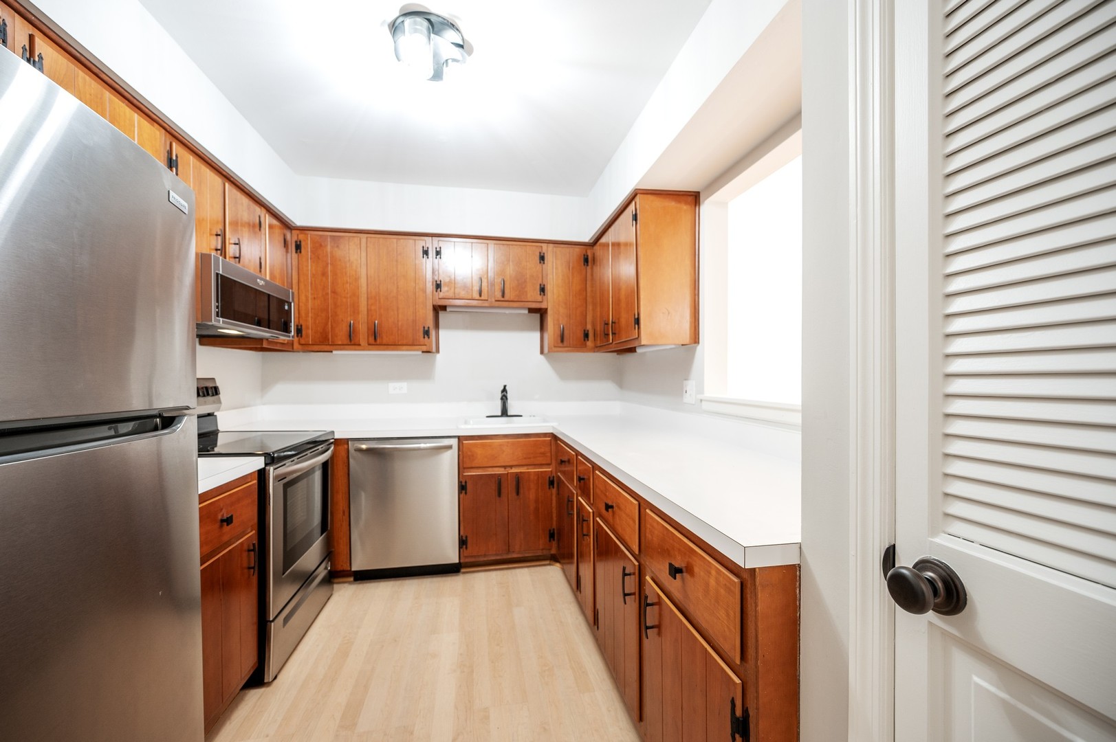 1982 Cherry Lane, Unit 15B Northbrook, IL 60062 - Photo 7 of 11 a kitchen with stainless steel appliances granite countertop a sink and a stove