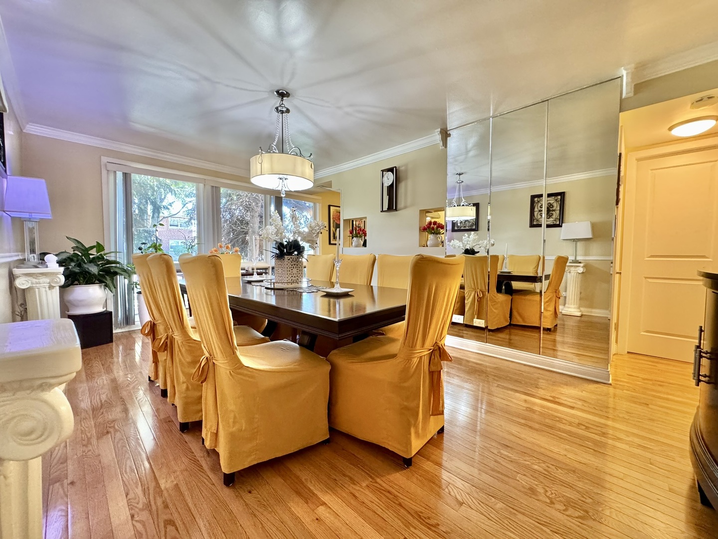 1247 South Mannheim Road, Unit 3 Westchester, IL 60154 - Photo 16 of 41 a dining room with wooden floor a chandelier a wooden table and chairs