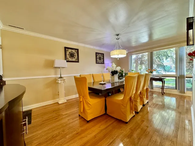 a view of a dining room with furniture a chandelier and wooden floor