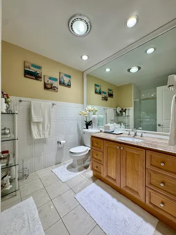 a bathroom with a double vanity sink mirror and toilet