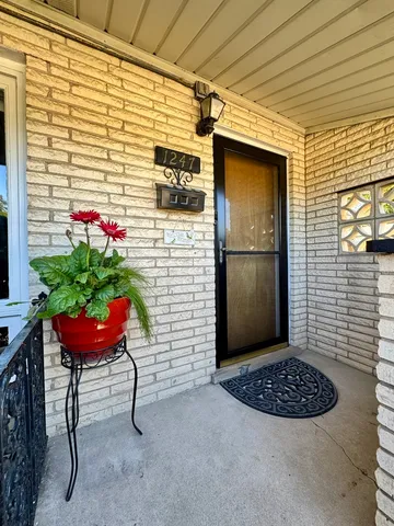 a view of a porch with a bench and a potted plant