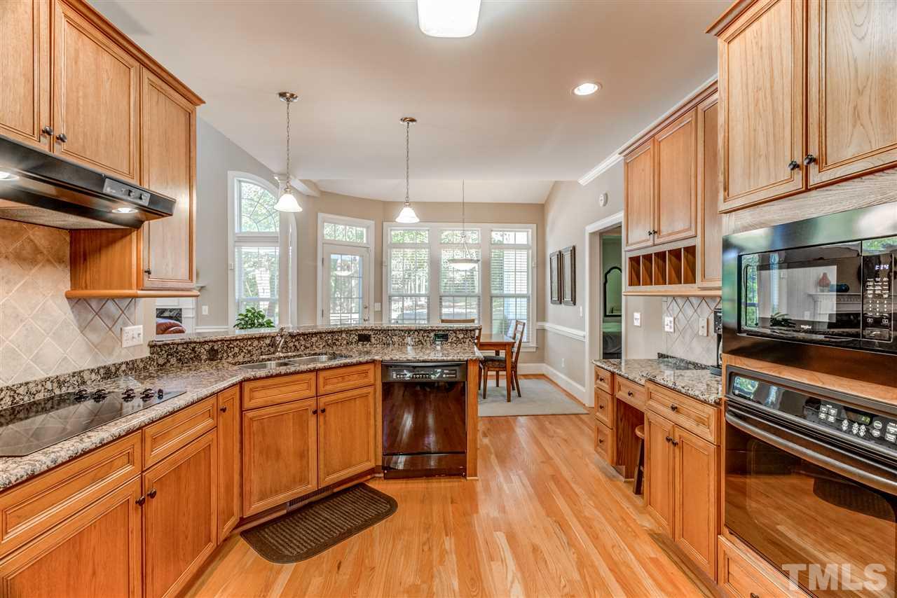 11604 John Allen Road Raleigh, NC 27614 - Photo 8 of 25 a kitchen with stainless steel appliances granite countertop a stove a sink dishwasher a refrigerator and white cabinets with wooden floor