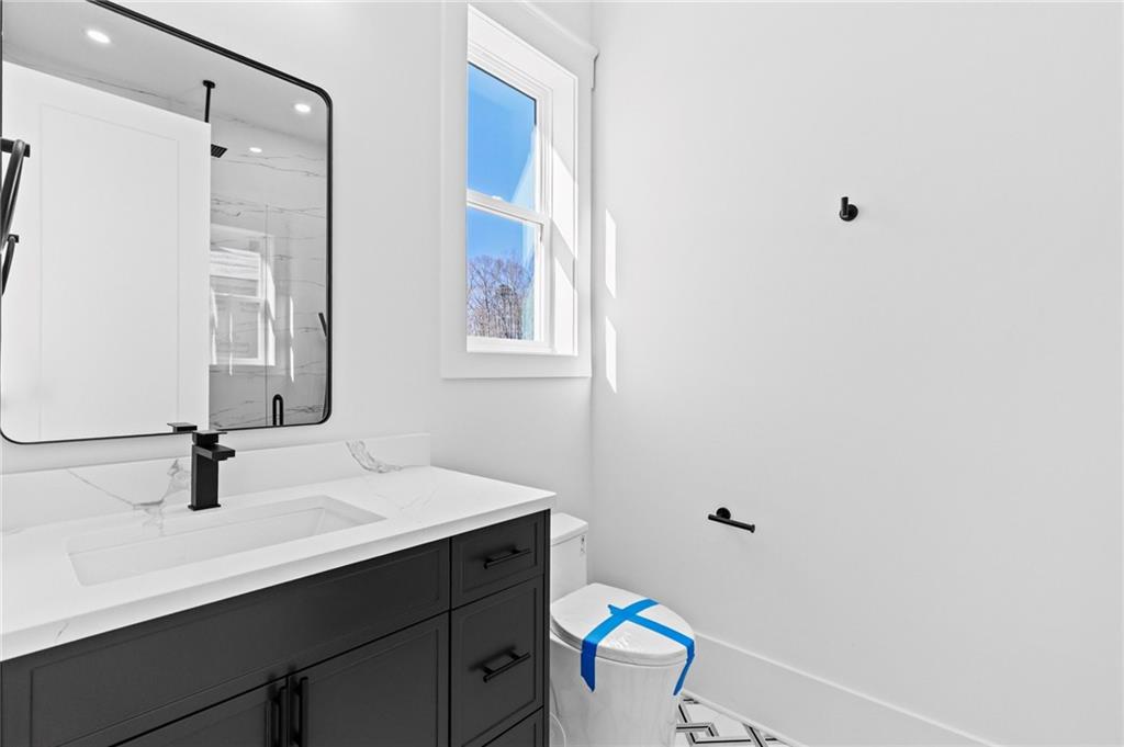 6996 Deaton Henry Road Hoschton, GA 30548 - Photo 34 of 65 a bathroom with a sink a toilet and a mirror